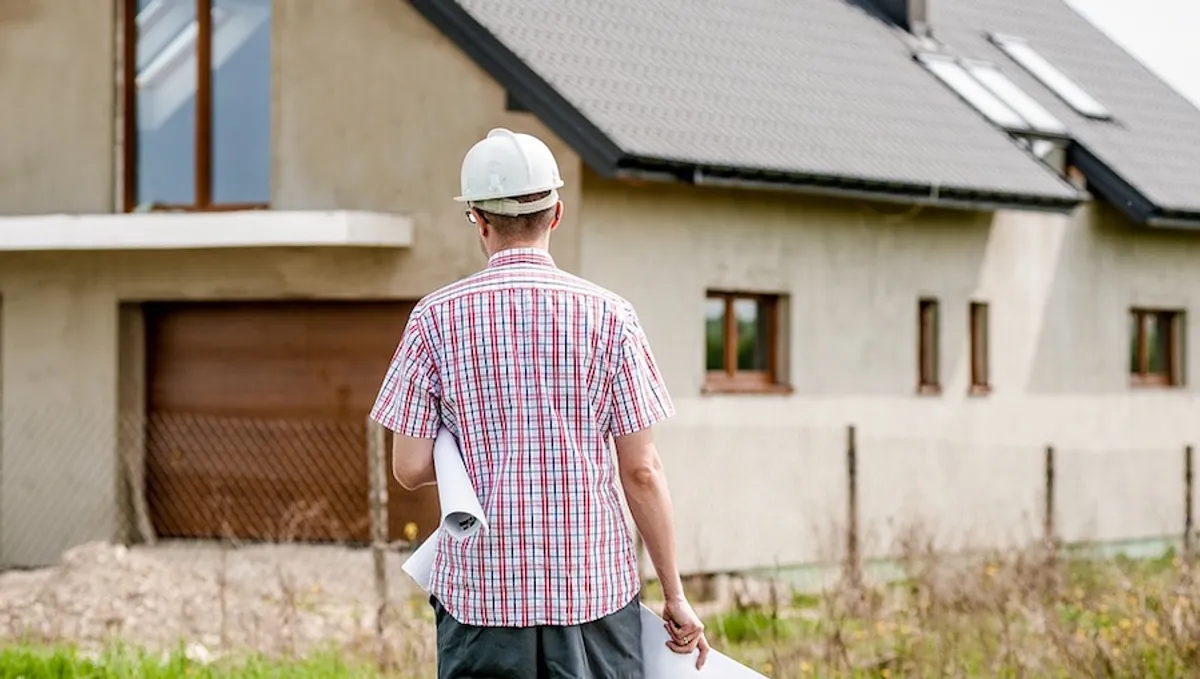 Kierownik budowy na placu budowy domu jednorodzinnego z dokumentacją projektową