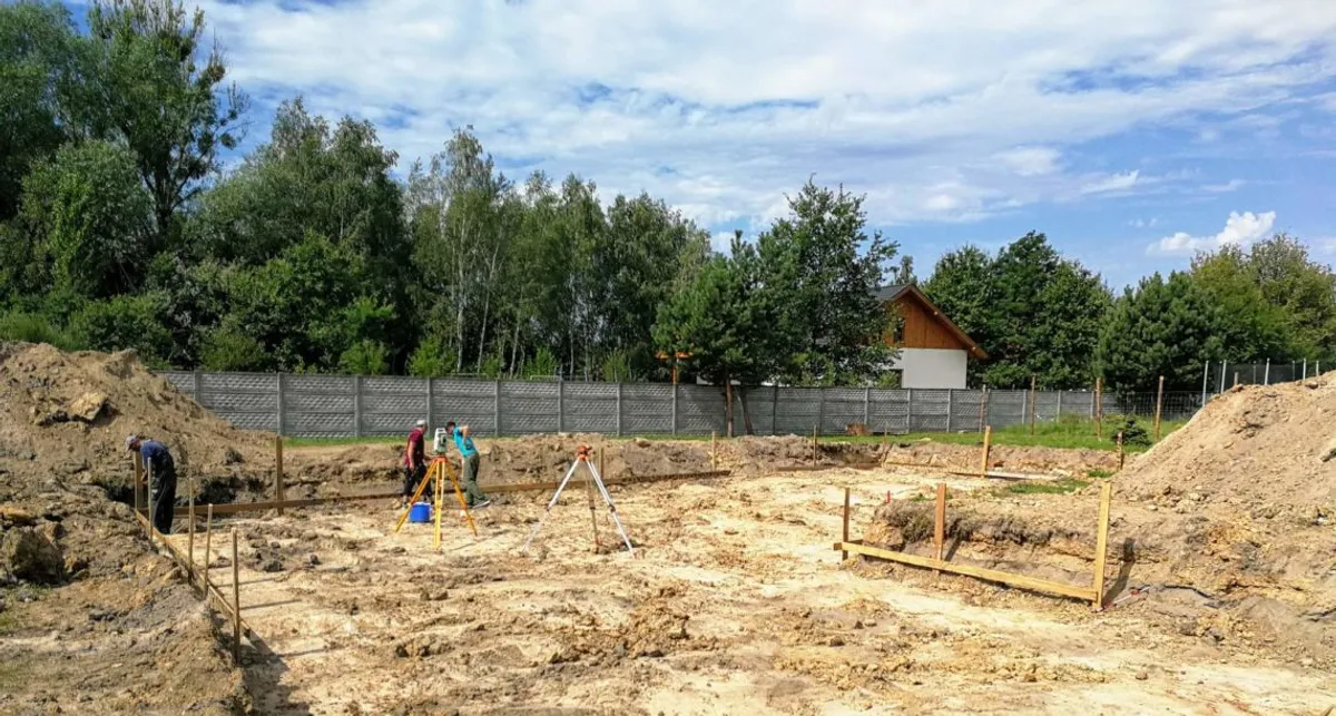 Wytyczanie ław fundamentowych przez geodetę na placu budowy - moment po uzyskaniu pozwolenia na budowę